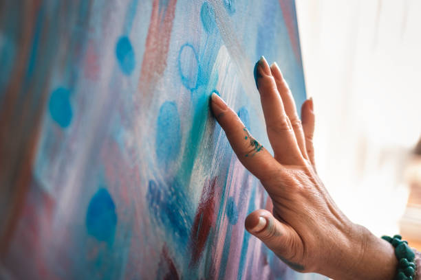 istock Artist painting on canvas by her hand 1299494569