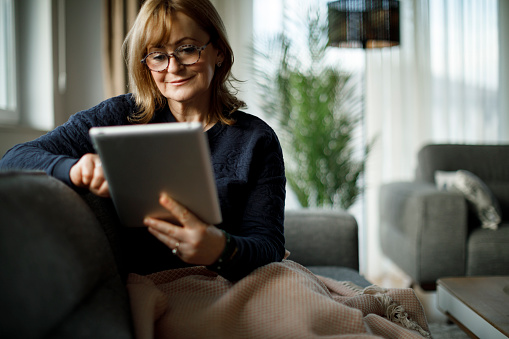 Smiling senior woman using digital tablet at home