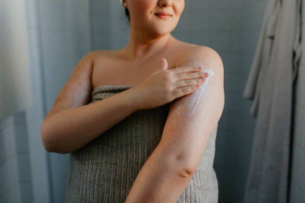 anonym överviktig kvinna som ansöker body lotion efter dusch - krämer bildbanksfoton och bilder