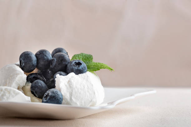 istock Bitten delicious meringue cake with fresh blueberries. Close up 1299496041