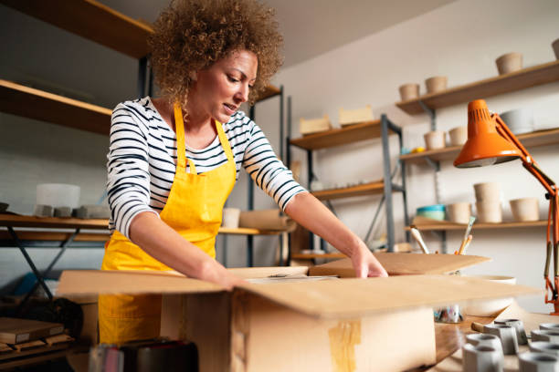 istock Craftswoman packing concrete pots in a cardboard box 1299496128