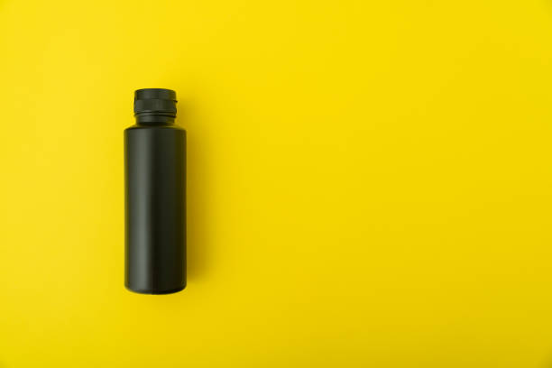 istock Black bottle vial on yellow background. Copy space. Mock up. 1299497157