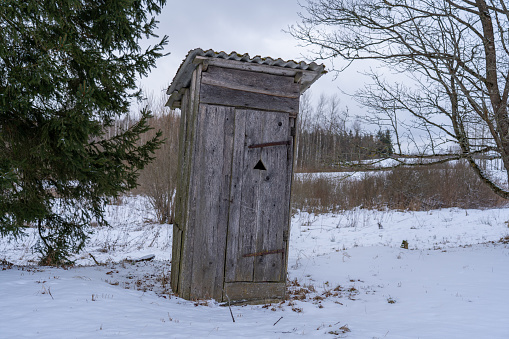 Old abandoned wooden outdoor toilet in the countryside