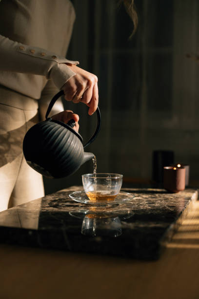 istock Tea Making: an Anonymous Woman Pouring Herself Green Tea 1299498393
