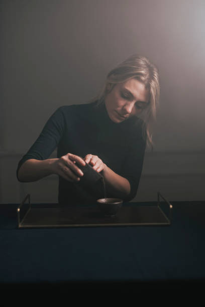 Traditional Tea Making: a Beautiful Young Blonde Woman Making Herself Tea
