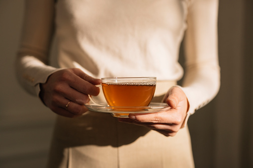 Healthy beverages: an unrecogniazble woman holding a cup of tea.