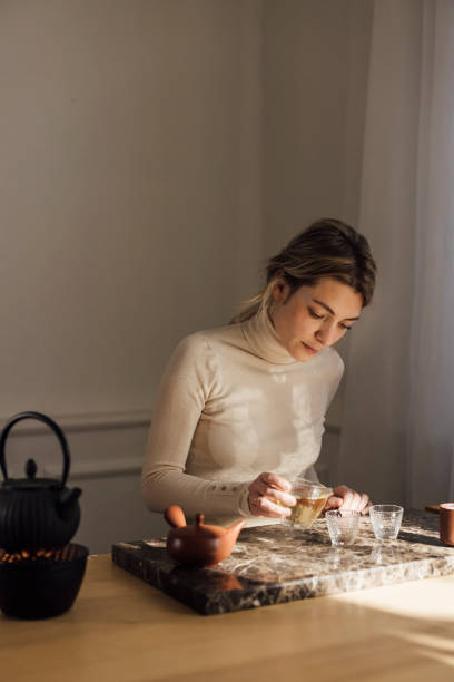 istock Traditional Tea Making: a Beautiful Young Blonde Woman Making Herself Tea 1299498420