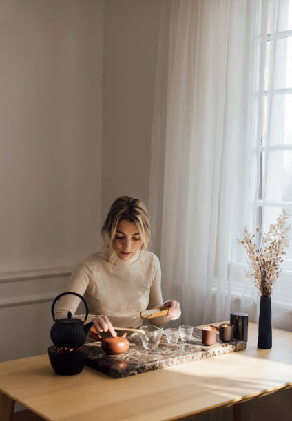 istock Traditional Tea Making: a Beautiful Young Blonde Woman Making Herself Tea 1299498432