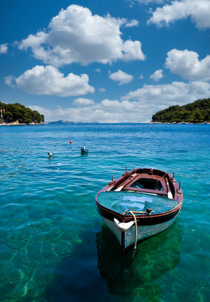 istock Blue Fishing Boat on Blue Water 1299500515