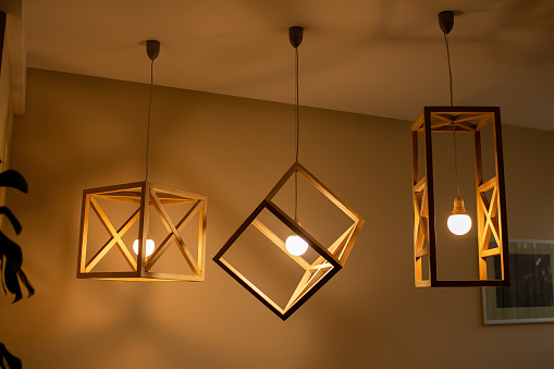 Modern ceiling lights bulbs lamp made of wooden frame geometric shape interior and loft style decorating with white wooden wall.