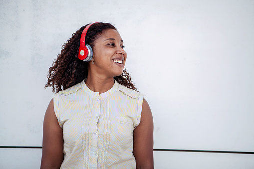 Beautiful black woman happy with headphone in white background.