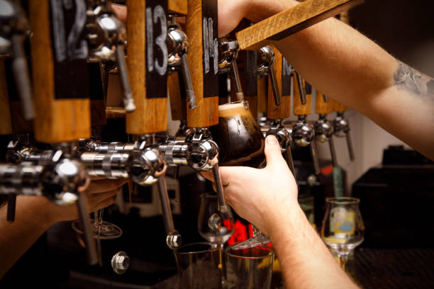 istock Bartender filling up a dark beer in a glass 1299504473