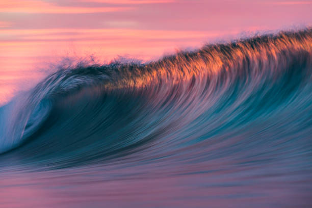 istock Cresting wave breaking in brilliant orange and golden morning light 1299506559
