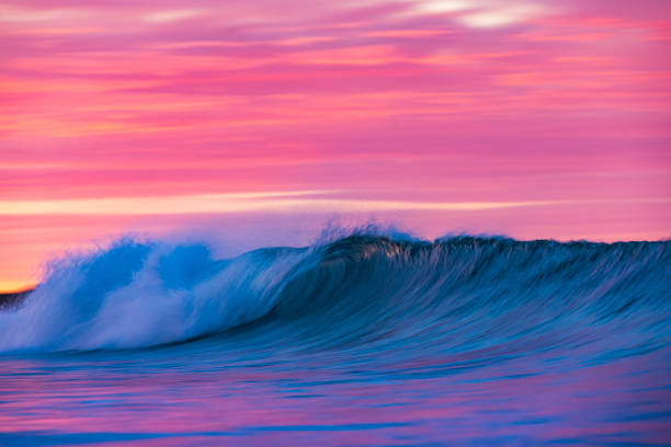 istock Cresting wave breaking in brilliant orange and golden morning light 1299506604