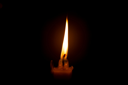 Burning candle with black background