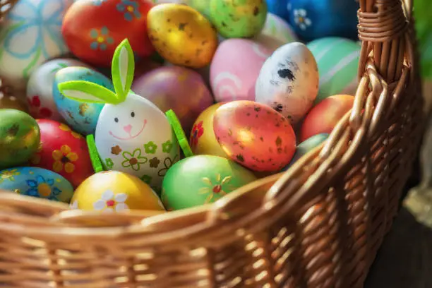 Easter decoration with crafted Easter bunny and eggs in the wicker basket. Spring Easter composition.