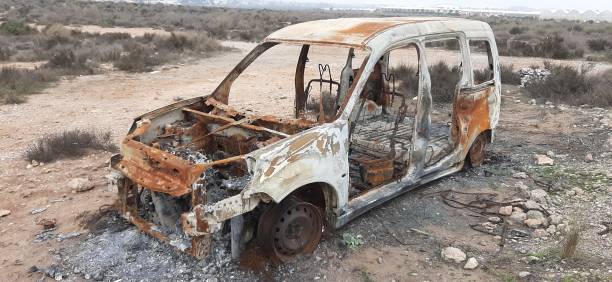 istock burned car abandoned, car destroyed by fire, mini van 1299510857
