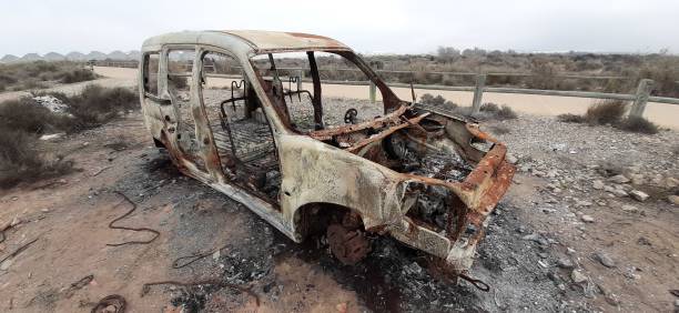 istock burned car abandoned, car destroyed by fire, mini van 1299510861
