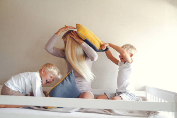 istock Mom gently hugs her little sons, they have fun 1299511558