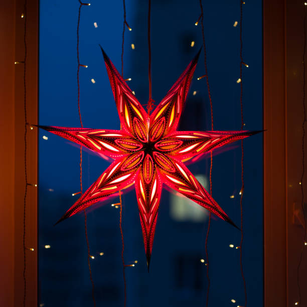 istock Glowing Christmas seven-ray star on the window on winter evening 1299516038