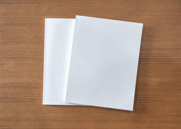 istock Book mockup with blank white front cover page a4 paperback mock up for catalog, magazine, menu, booklet, notebook, portfolio design template on wood table background 1299516130