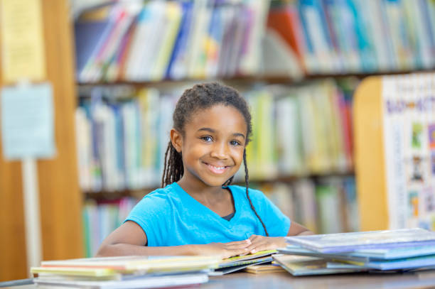 istock School girl sitting at a table in the library 1299516272
