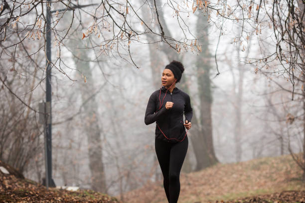 istock Young lady is jogging in misty forest. 1299518130
