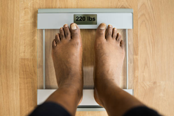 istock Obesity And Weightloss. Feet On Weight Scale 1299523631