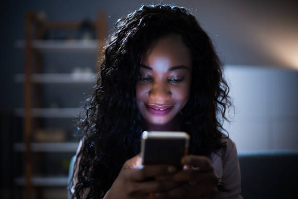 istock African Woman Using Mobile Phone Or Smartphone At Night 1299523690