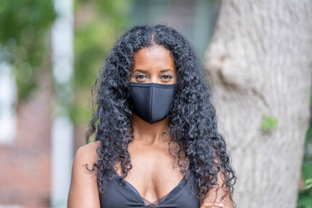 istock Beautiful African woman wearing a face mask 1299525885