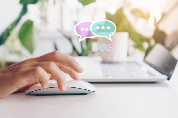 istock People hand using laptop typing, chatting or text  messages in chat icons pop up. Social media maketing technology concept. Vintage soft color tone background. 1299526550