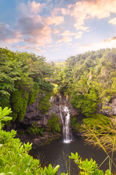 istock Tropical waterfall with cloudy forests and spectacular sky in Hawaii 1299528085
