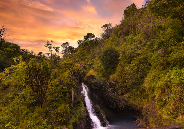 istock Tropical waterfall with cloudy forests and spectacular sky in Hawaii 1299528123