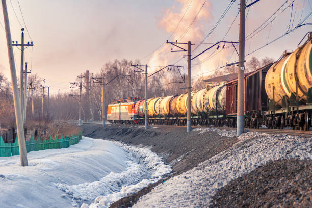 istock freight train leaving a bend, trees behind an industrial area, winter evening 1299532543