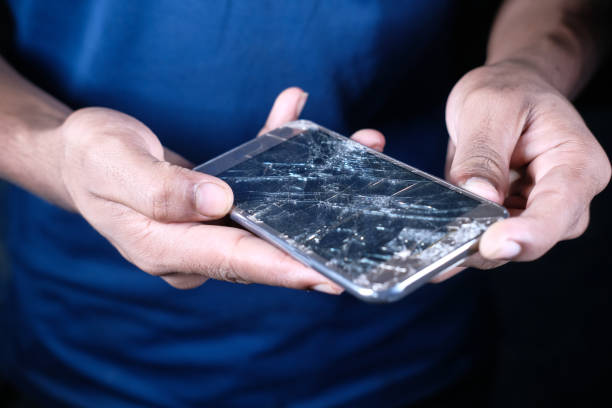 istock Close up of man hand holding broken smart phone. 1299533634