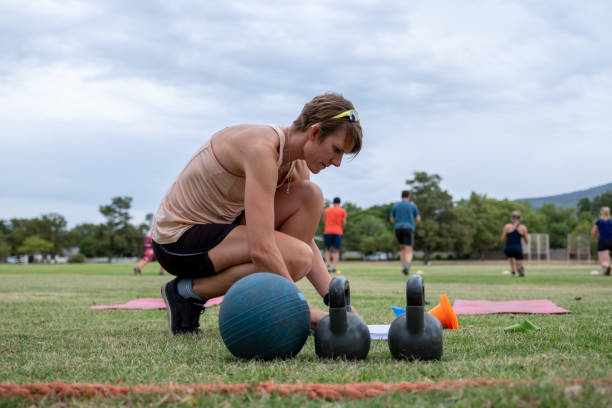 istock Fitness instructor leads an outdoor gym session on the open fields 1299536887