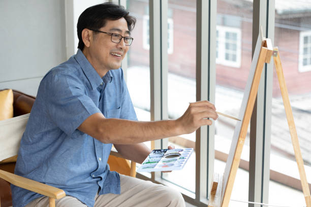 istock senior asian man painting at home 1299543968