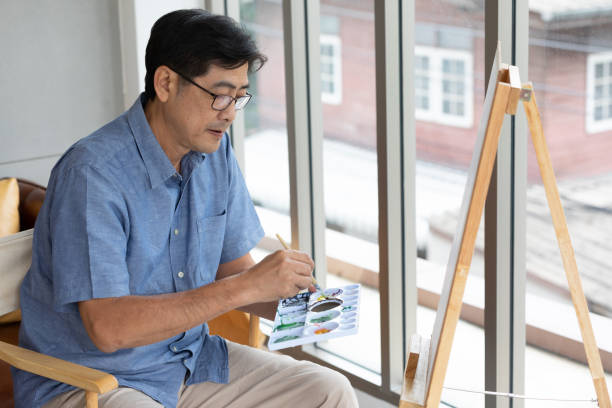 istock senior asian man painting at home 1299543969