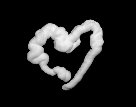 Heart shaped shaving foam isolated on black background