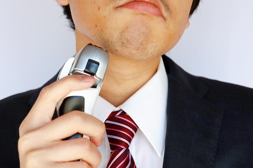 Close-up of a Japanese man in a suit with a goatee.