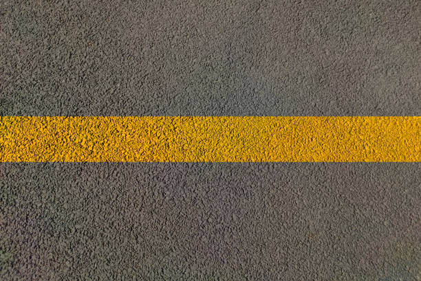 istock Road view with lines on yellow continues lines across Highway for two side traffic movement by dividing lane on highway to control transportation 1299547744