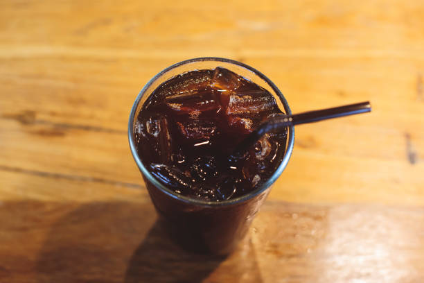 istock Iced black coffee in a glass is on a wooden table. 1299548781
