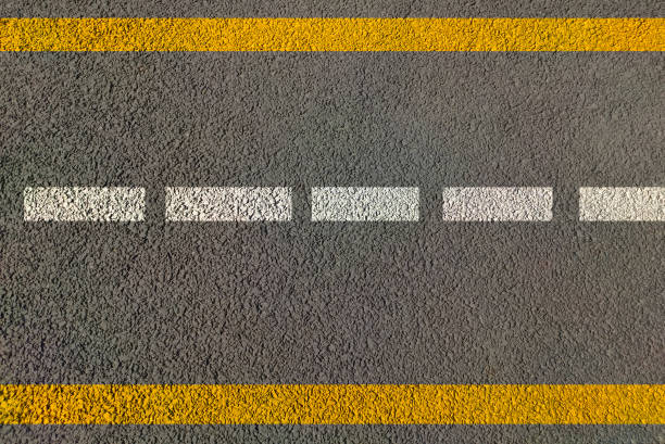 istock Road marking for lane driving , highways painted in white and yellow lines both direction traffic movement control by use of sign and symbols of traffic 1299548827