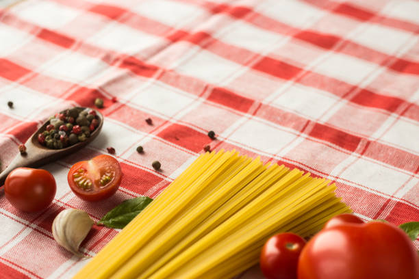 istock Marinara pasta ingredients lie on a checkered tablecloth. raw tagliatelle with spices and small cherry tomatoes 1299551554