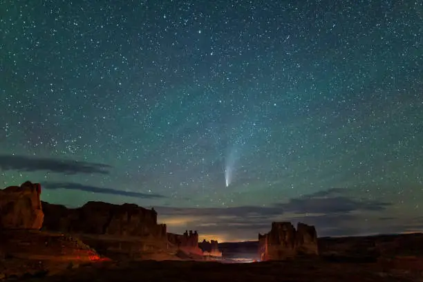 Neowise C/2020 F3 Comet silhouetted against the Courthouse Towers valley from the La Sal Mountains Viewpoint in Arches National Park in Moab, Utah.