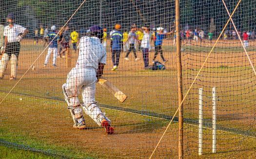 Mumbai, India - December 20, 2020: Unidentified boy practicing batting to improve cricketing skills at Mumbai ground