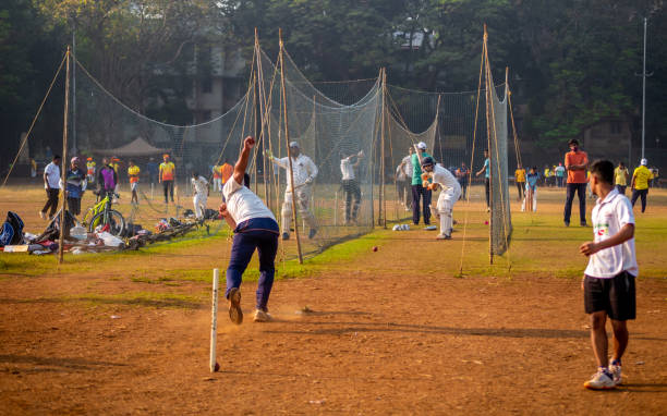 niño no identificado practicando bateo para mejorar habilidades de cricket en terreno de mumbai - sport of cricket practicing cricket player net fotografías e imágenes de stock