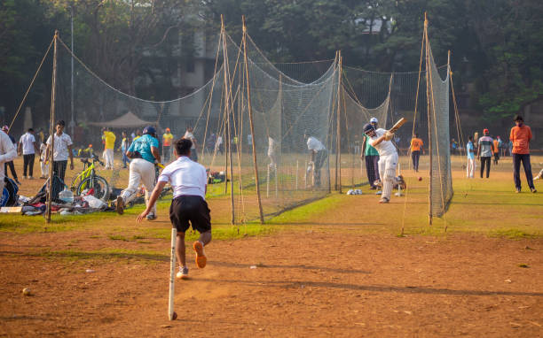 niño no identificado practicando bateo para mejorar habilidades de cricket en terreno de mumbai - sport of cricket practicing cricket player net fotografías e imágenes de stock
