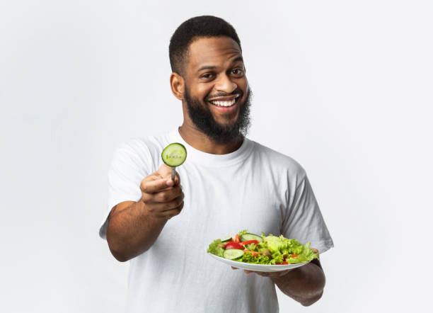 istock Cheerful Black Man Holding Salad Standing On White Background, Studio 1299556058
