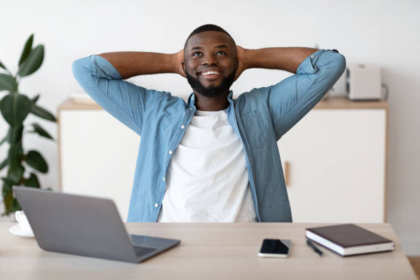 istock Positive Black Male Freelancer Leaning Back In Chair, Resting At Workplace 1299556693